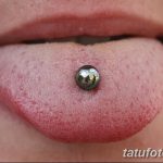 Фото пирсинга языка с серебристым шариком. Крупный план демонстрирует прокол и блеск украшения.