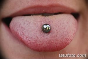 Фото пирсинга языка с серебристым шариком. Крупный план демонстрирует прокол и блеск украшения.