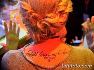 Фото тату: Надпись "Love lives in my heart" на шее девушки. Элегантный шрифт и романтичный дизайн.