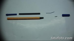 Фотография разложенных деталей для сборки самодельной тату-машинки: ручка, пружина, игла и другие элементы.