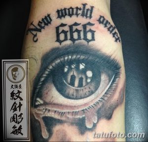 Фото татуировки с изображением глаза с числом 666 и надписью 'New World Order'. Рисунок татуировки в стиле New School.