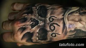 Фото тату черепа с числом 666 на руке. Черно-серый рисунок татуировки с детальной проработкой костей и трещин.