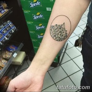 Фото тату: оригинальная татуировка в виде логотипа Sprite на руке. Геометрический рисунок, состоящий из треугольников, выполненный в черном цвете.