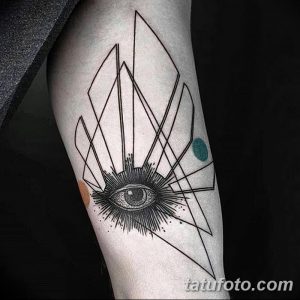 Черно-белая татуировка на предплечье, изображающая глаз, окруженный геометрическими фигурами. Стиль - абстракция и минимализм.