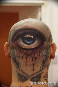 Фото тату на затылке: реалистичный рисунок глаза, из которого текут слезы. Выполнено в черно-серых тонах с высокой детализацией, создающей драматический эффект.