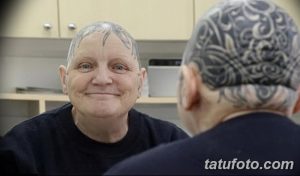 Фото тату: голова пожилого мужчины, полностью покрытая сложным узором татуировки. Черно-серые тона и детализированные рисунки.