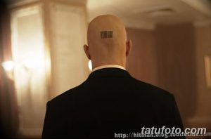 Фото тату с изображением штрих-кода на затылке. Черная татуировка в минималистичном стиле, имитирующая идентификационный код. Необычный и оригинальный рисунок татуировки.