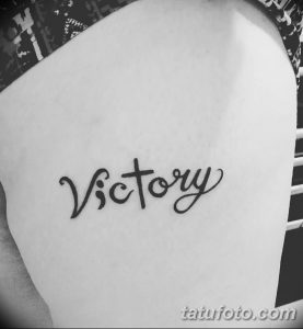Фото тату: надпись 'Victory' выполненная элегантным шрифтом на руке, символизирующая победу, триумф и личные достижения.