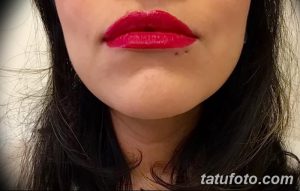 Фото тату: Женские губы, накрашенные яркой красной помадой, с небольшим пирсингом. Акцент на выразительности губ и контрасте цветов.