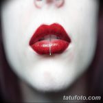 Фото пирсинга нижней губы с тонким серебристым кольцом на фоне яркого красного макияжа и бледной кожи. Идеи для готического пирсинга.