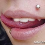Фото девушки с пирсингом нижней губы и носа. У нее также есть пирсинг уха. Подчеркивает неординарность и смелый стиль.