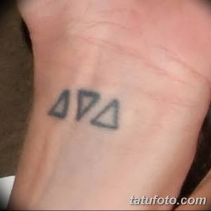 Фото тату: минималистичная татуировка из трех треугольников, расположенных на боку. Черно-белый рисунок татуировки.