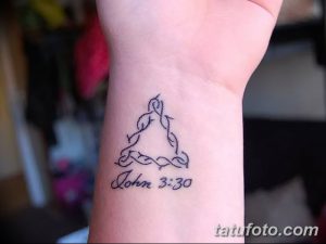 Фото тату с изображением треугольника, внутри которого надпись 'John 3:30' на запястье. Небольшой религиозный рисунок татуировки.