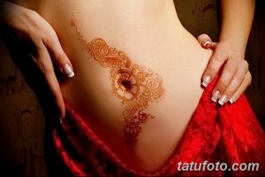 Фото тату хной на боку и животе: сложный цветочный узор в коричневых тонах, плавно переходящий от бока к животу.