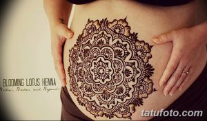 Фото тату хной на животе беременной женщины. Сложный узор мандалы в коричневых тонах, детальная проработка, красивый дизайн.