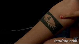 Фото тату: Татуировка в виде глаза, заключенного в прямоугольник, на запястье. Черный рисунок на светлой коже.