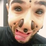 Фотография мужчины с экстремальными модификациями тела, включая татуировки на лице и многочисленный пирсинг.