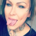 Фотография девушки с татуировками на шее, ключицах и руках. Девушка высунула язык, демонстрируя дерзкий и бунтарский настрой.