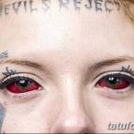 Фотография девушки с татуировками на лице и надписью "Devil's Reject" на лбу. Изображение демонстрирует экстремальный стиль модификации тела.