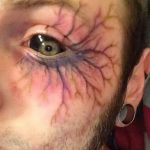 Фото татуировки, имитирующей синяк под глазом. Реалистичный рисунок, выполненный в технике, создающей эффект объемности и повреждения кожи.
