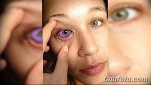 Фото девушки с фиолетовыми глазами и татуировкой на лице. Альтернативный стиль, современный образ, яркий акцент.