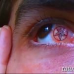 Фото глаза с татуировкой в виде красной пентаграммы на радужке. Экстремальный и провокационный дизайн, демонстрирующий смелость и бунтарский дух.