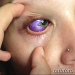 Фото тату: девушка с фиолетовой радужной оболочкой глаза, созданной с помощью татуировки. Крупный план лица, акцент на глазах.