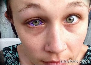 Фото тату: девушка с фиолетовой радужкой глаза, созданной с помощью татуировки. Крупный план лица, акцент на глазах.