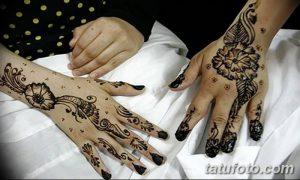 Фото тату хной на руках: симметричные рисунки с цветочными мотивами и сложными узорами, выполненные в коричневых тонах.