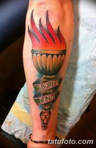 Фото тату на руке: факел с пылающим пламенем и надписью 'BURN INFINITE', выполненный в ярких цветах.