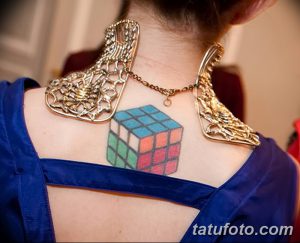 Фото татуировки кубика Рубика на спине, выполненной в ярких цветах. Оригинальный эскиз тату для любителей головоломок и ярких рисунков.