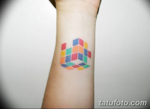 Фото минималистичной татуировки кубика Рубика на запястье, выполненной в ярких цветах. Идеальный эскиз тату для любителей лаконичности.