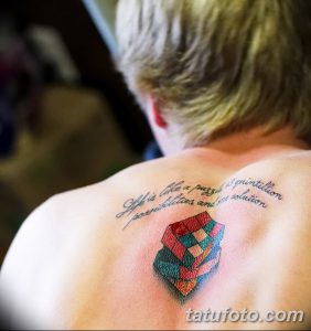 Фото тату кубика Рубика на плече с надписью "Life is like a puzzle..." Черно-белая графика, каллиграфия, философский смысл.