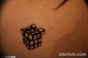 Фото тату: контурный рисунок кубика Рубика на спине. Черно-белая графика, минимализм, простой дизайн.