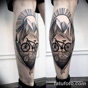Фото тату на голени: велосипед на фоне гор, выполненный в технике blackwork. Черно-белый рисунок татуировки с использованием точек и линий.