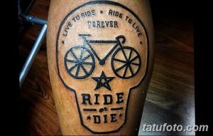 Фото татуировки велосипеда внутри черепа с надписью "Live to Ride Forever, Ride or Die". Черно-белый рисунок, смелый дизайн.