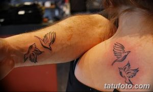 Небольшие татуировки с изображением летящих птиц, выполненные в минималистичном стиле на руке и плече. Тонкие линии и светлые оттенки.