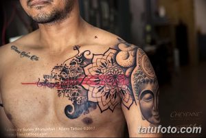 Фото тату на груди и плече: изображение Будды и сложной мандалы с красными акцентами, выполненное в черных тонах.
