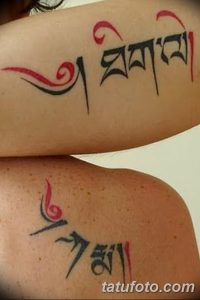 Фотография двух татуировок на руках, представляющих собой тибетские символы, выполненные черными и красными чернилами. Изображения имеют абстрактный вид.