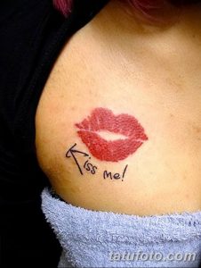 Фото тату на ключице с изображением красного отпечатка губ и надписи 'Kiss Me!'. Чувственный и привлекательный рисунок татуировки.