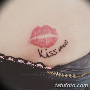 Фото тату: реалистичный отпечаток губ и надпись 'Kiss me' на талии, выполненные в красных тонах.