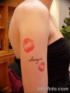 Фото тату: отпечаток губ и надпись 'I love you' на руке, выполненные в красных тонах.
