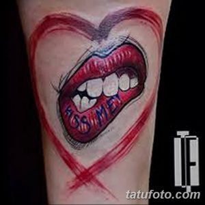 Фото тату: изображение женских губ с надписью "Kiss Me" внутри красного сердца на руке. Подходит для тех, кто ищет яркие и романтичные эскизы тату.