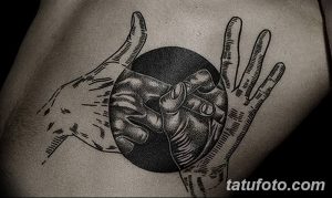 Фото тату на боку: черно-белая татуировка в стиле графика с изображением двух рук, держащих сердце. Простые линии и минималистичный дизайн.