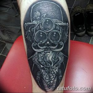 Фото татуировки на руке, изображающей стилизованного монстра в стиле blackwork. Геометрический рисунок татуировки с использованием только черного цвета.