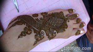 Фото тату хной на стопе, восточный узор, коричневые оттенки, женская нога, детальная проработка, цветочные мотивы.