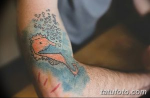 Фото тату с изображением морского конька в акварельном стиле на руке. Использование пастельных тонов и мягких линий создает нежный и романтичный образ.