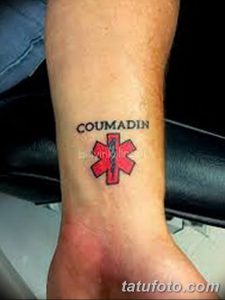 Фото тату на руке с надписью "Coumadin" и символом медицинской помощи (крест со змеей). Рисунок татуировки выполнен в простом, минималистичном стиле.