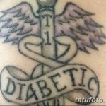 Фото тату на запястье: шприц с крыльями и надписью 'DIABETIC'. Татуировка для людей, страдающих диабетом.