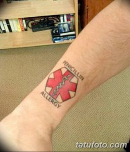 Фото тату на запястье: красный крест 'Звезда жизни' с надписью 'Penicillin Allergy'. Предупреждающая татуировка для людей с аллергией.